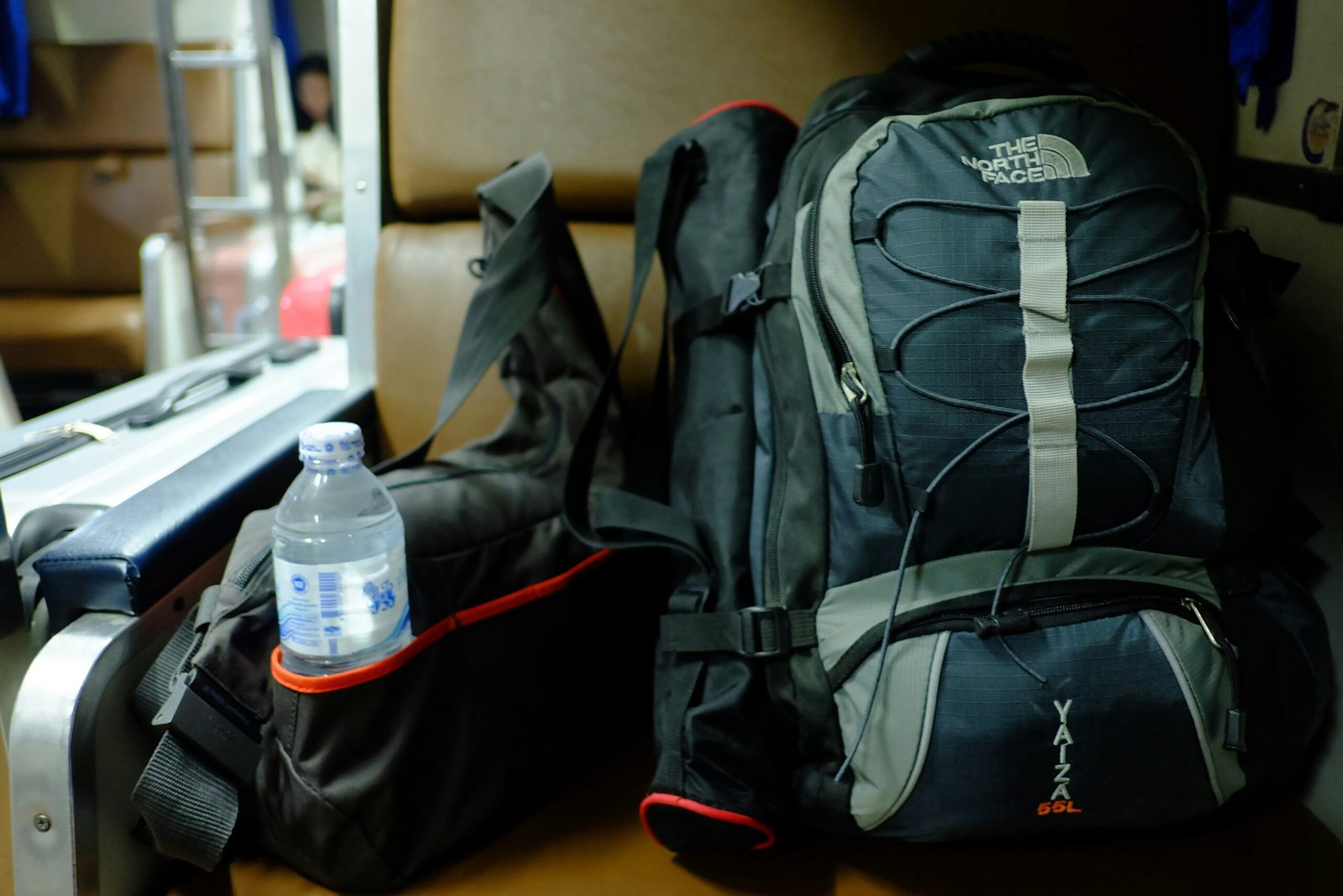 A backpack filled with desert survival essentials including water bottles, snacks, and sunglasses