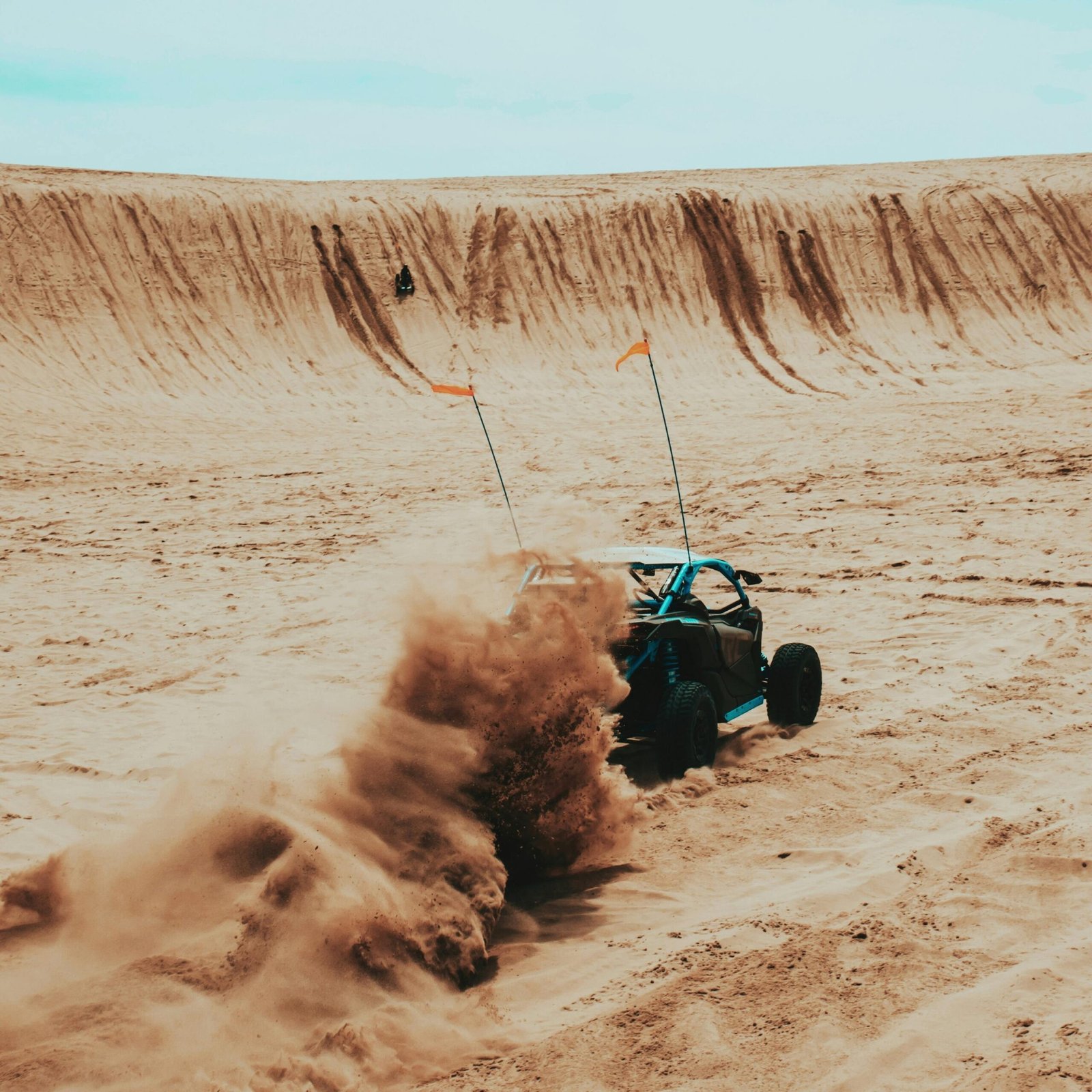 A dune buggy speeding through sand dunes