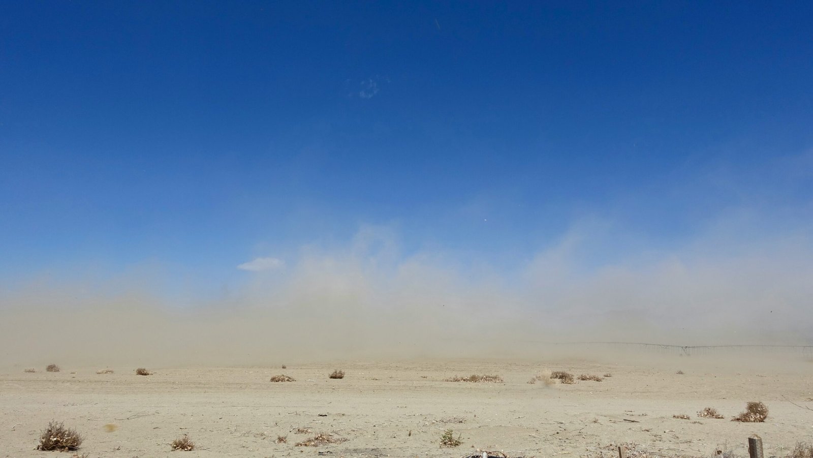 A vast sandy desert with dramatic skies highlighting temperature extremes