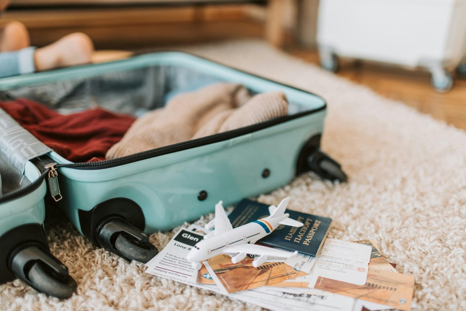 An adventurer carefully packing solar chargers, wrapped lenses, and protective bags for his devices.