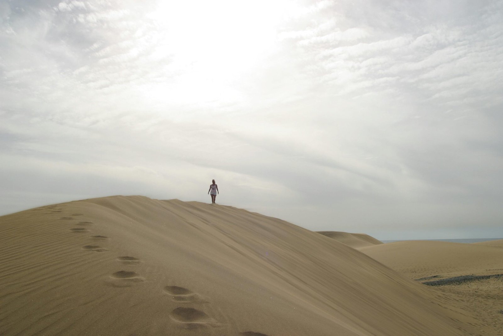 Ancient ruins amidst golden sand dunes under a blue sky