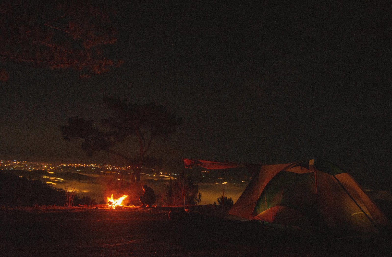 Tourists gathered around a cozy campfire under starlit skies