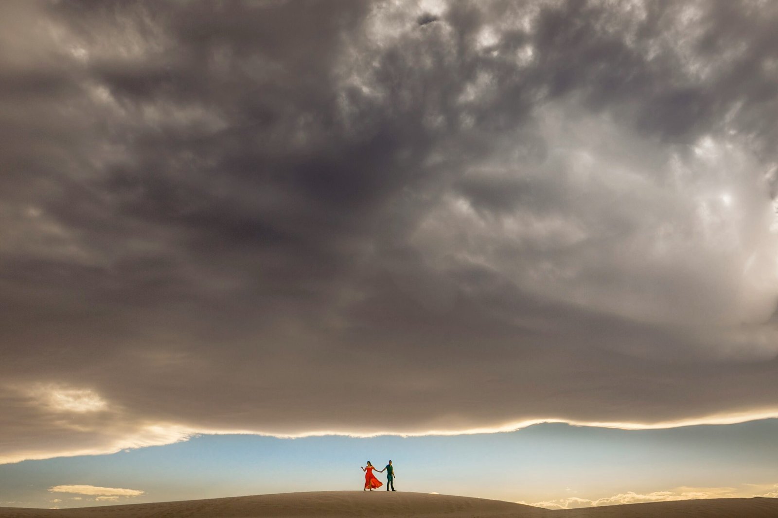 Two friends setting up awning under desert sky