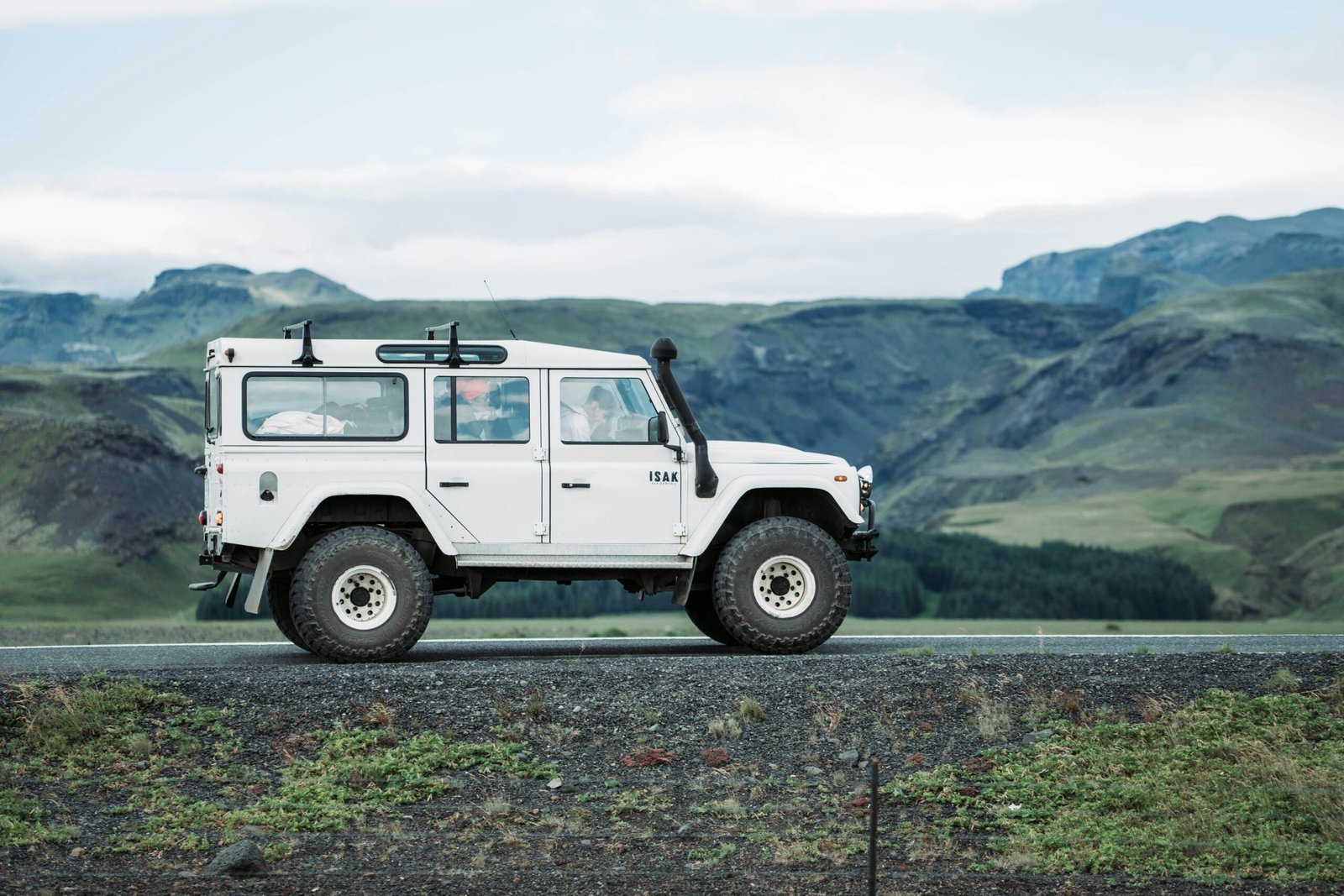A smiling tour operator standing next to a rugged 4x4 vehicle ready for adventure