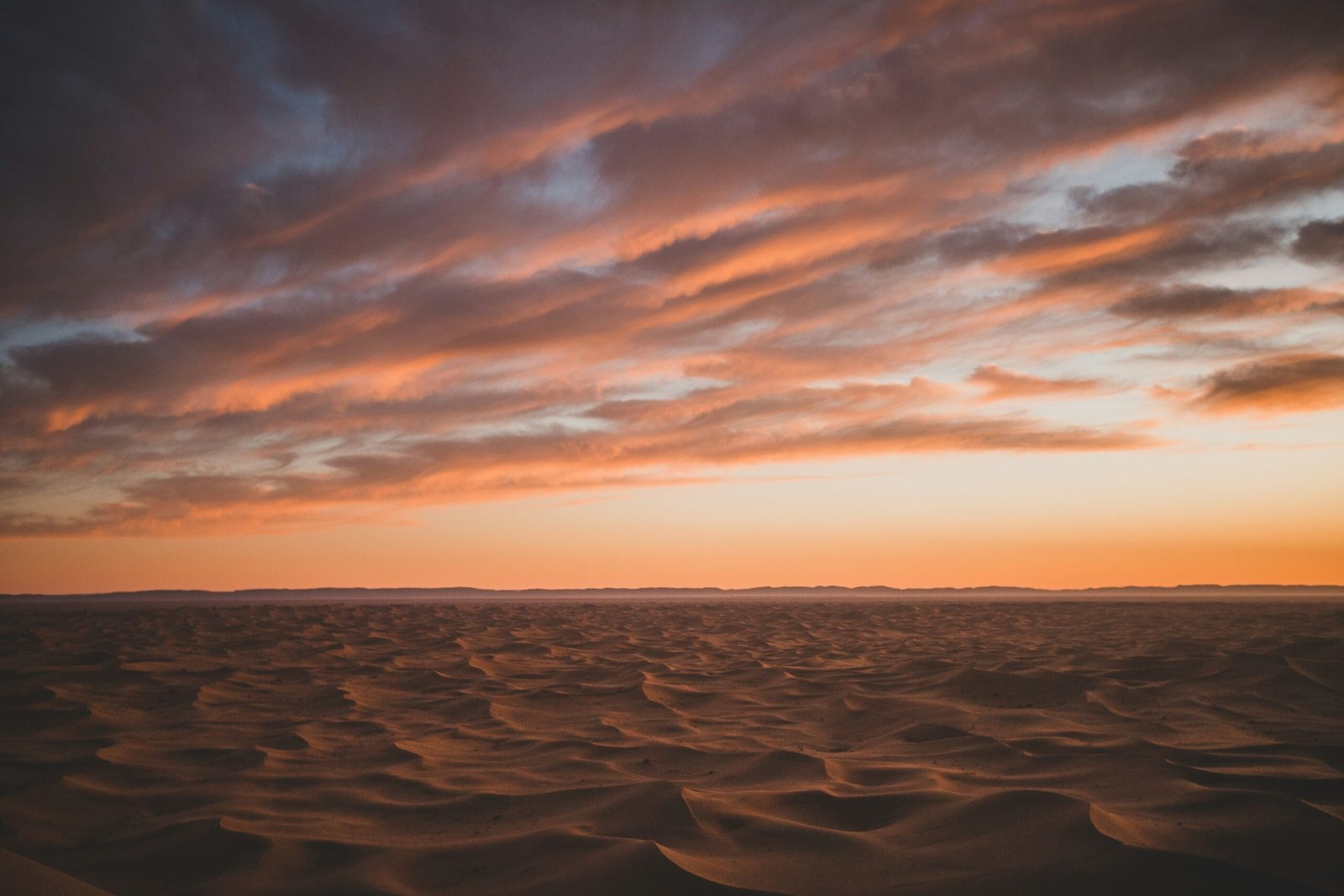 Golden sand dunes under a blazing sunset during a desert safari