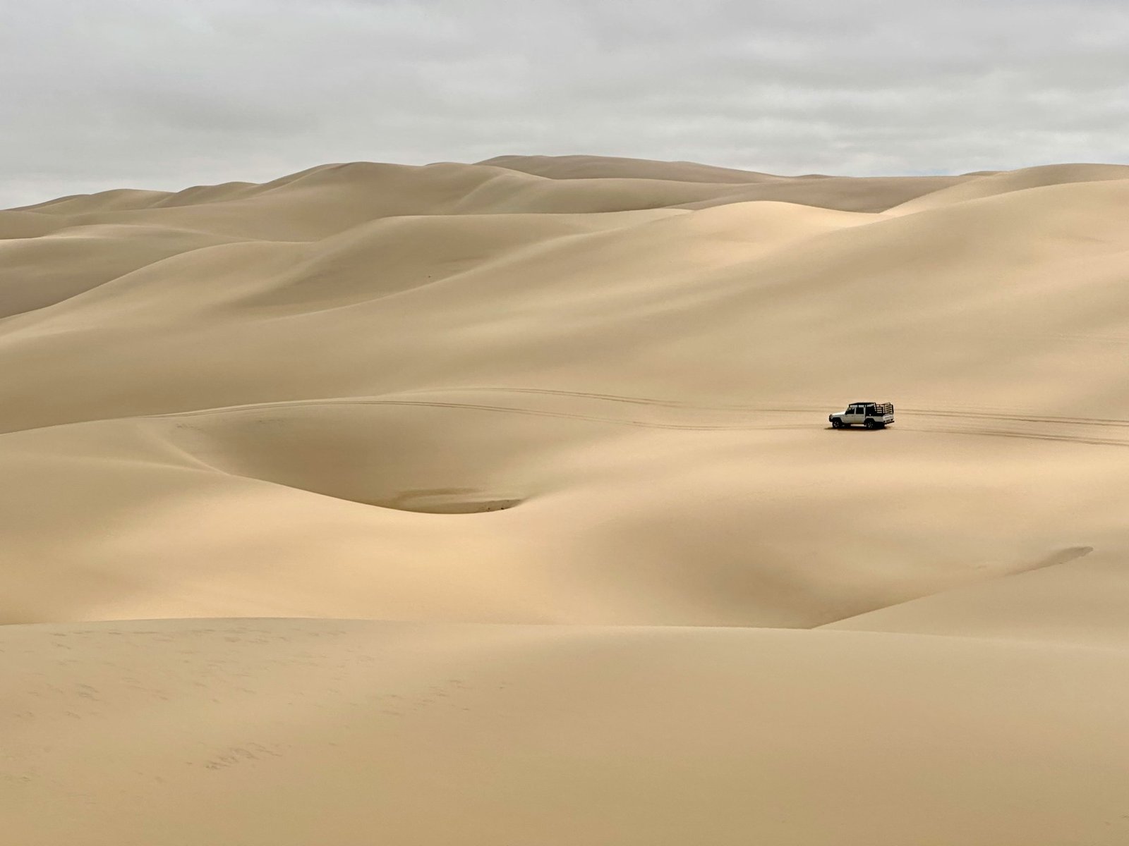 Golden sand dunes under a clear blue sky during an off-road desert safari