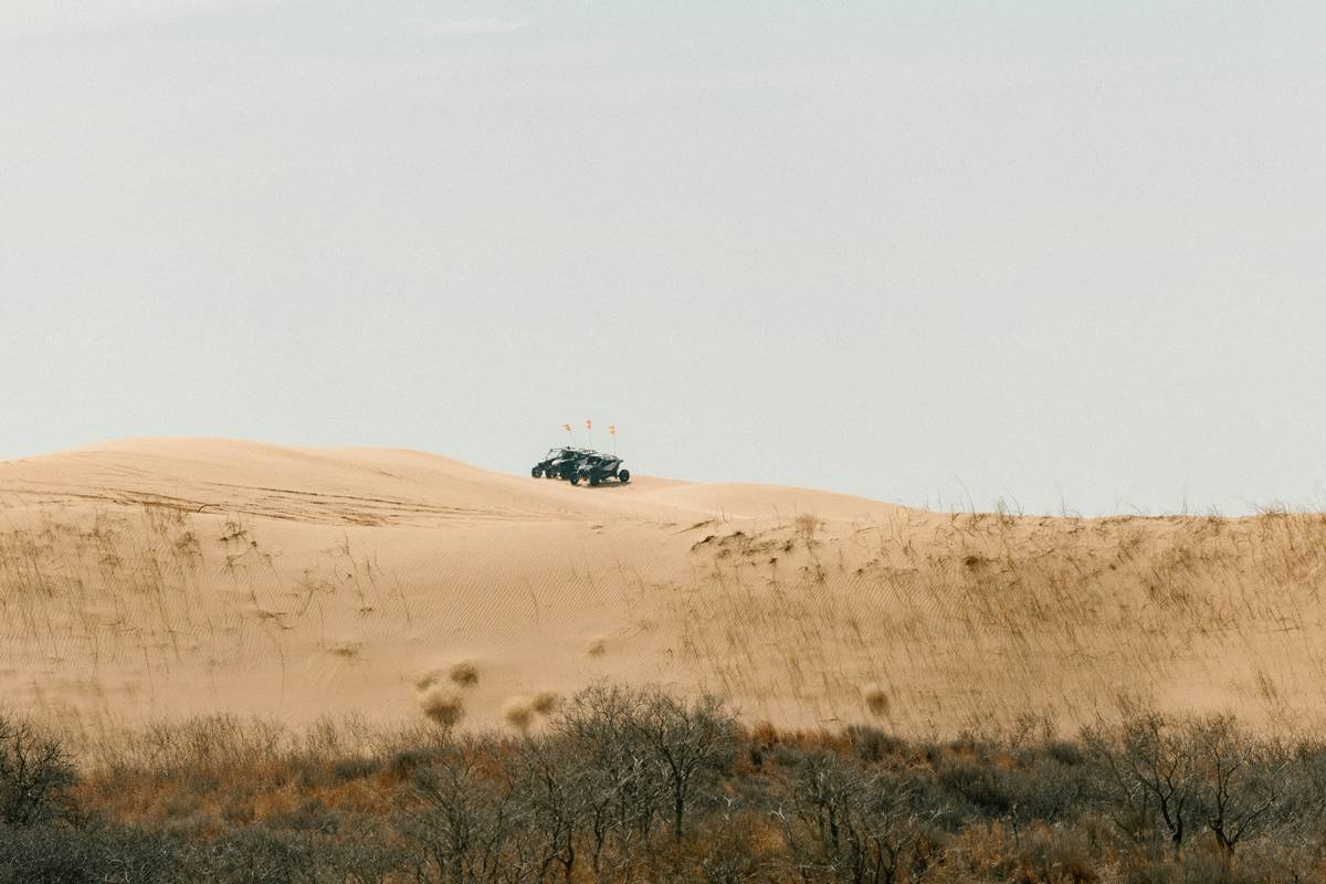 Luxury SUV driving through massive sand dune