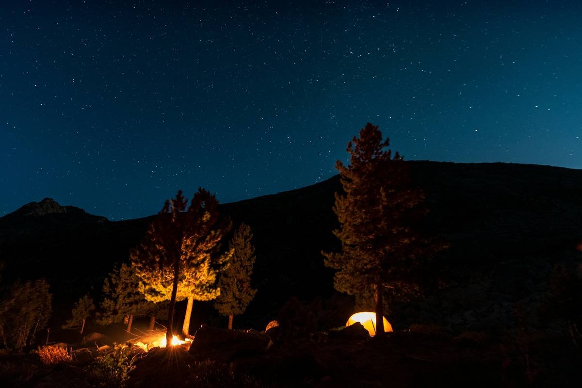 A breathtaking sunset over vast golden dunes, capturing the serene beauty of an overnight dune adventure.