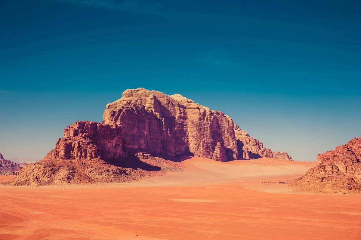 Group of tourists enjoying sandboarding on massive dunes