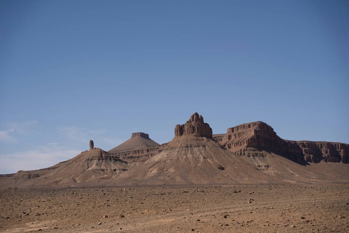 Tourists gathering around a campfire at night during the Hamada Rock Desert Tour