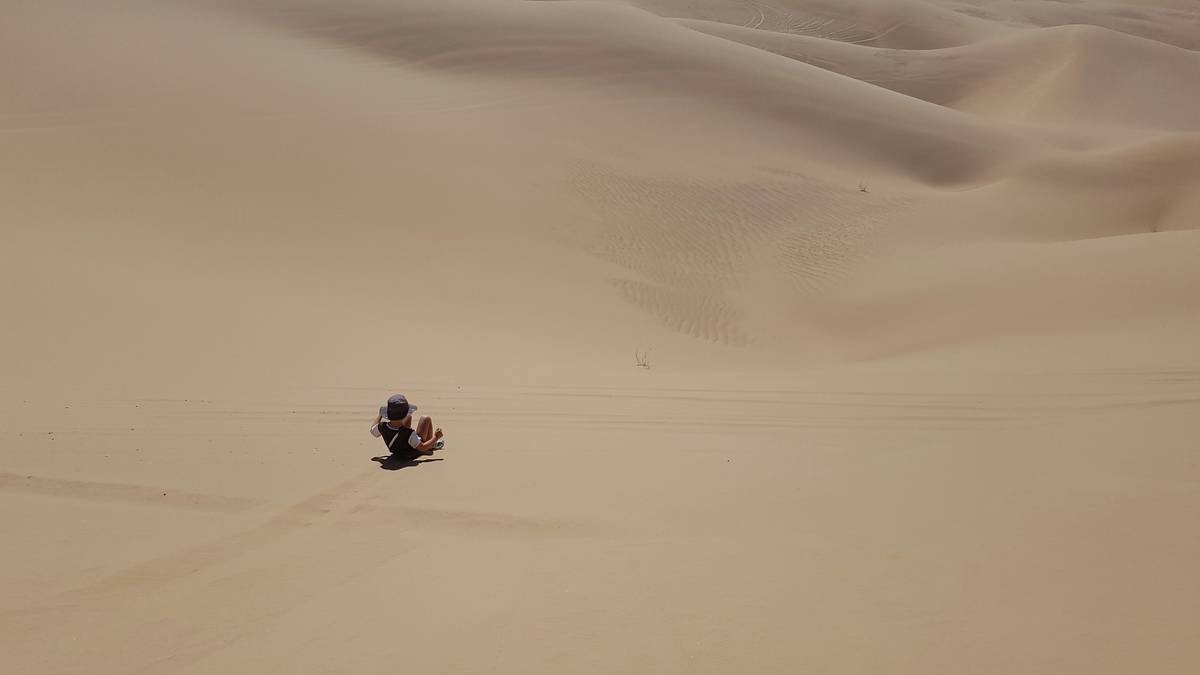 Tourists riding quad bikes across sandy terrain