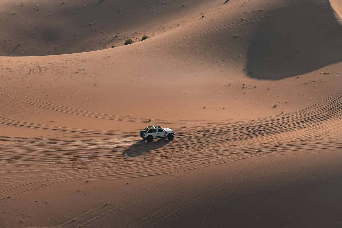 Comparison infographic showing Toyota Land Cruiser 70 Series, Nissan Patrol Y62, and a non-modified SUV side-by-side with key specs: suspension type, tire pressure, roll cage presence
