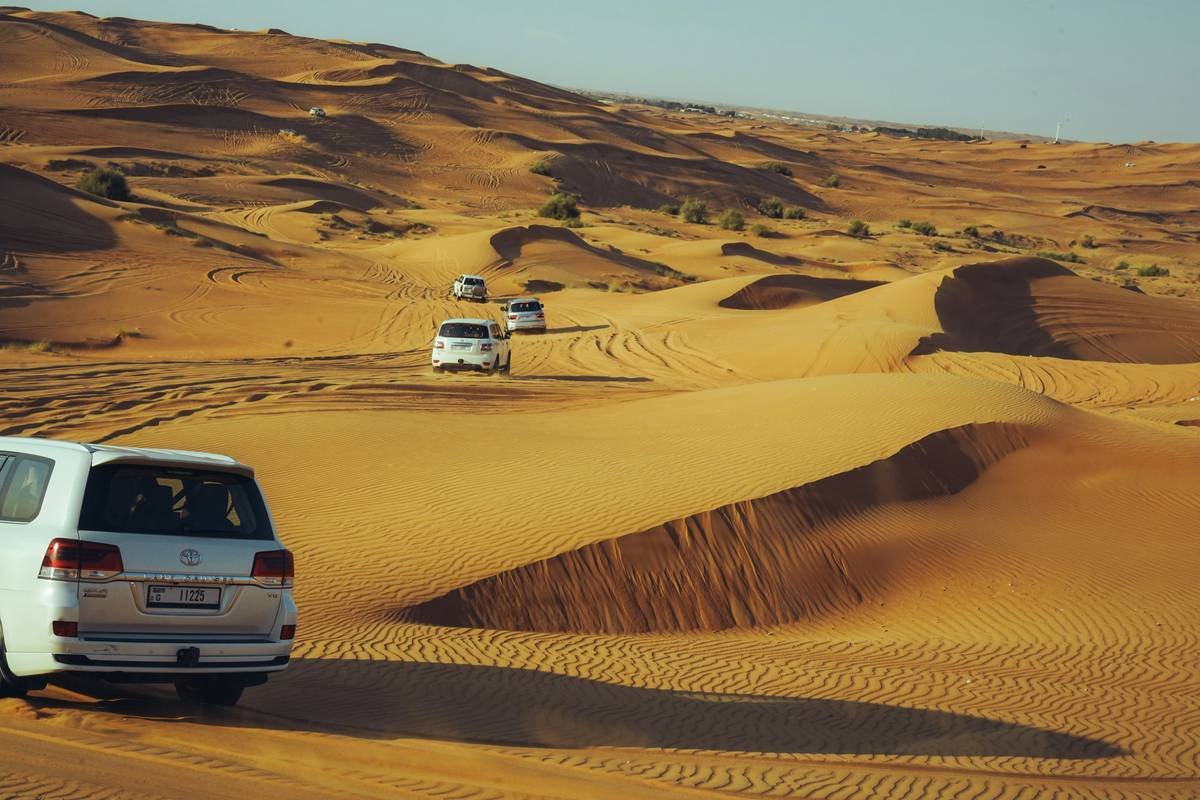 Close-up of experienced driver performing desert dune bashing dubai maneuver on steep sand ridge